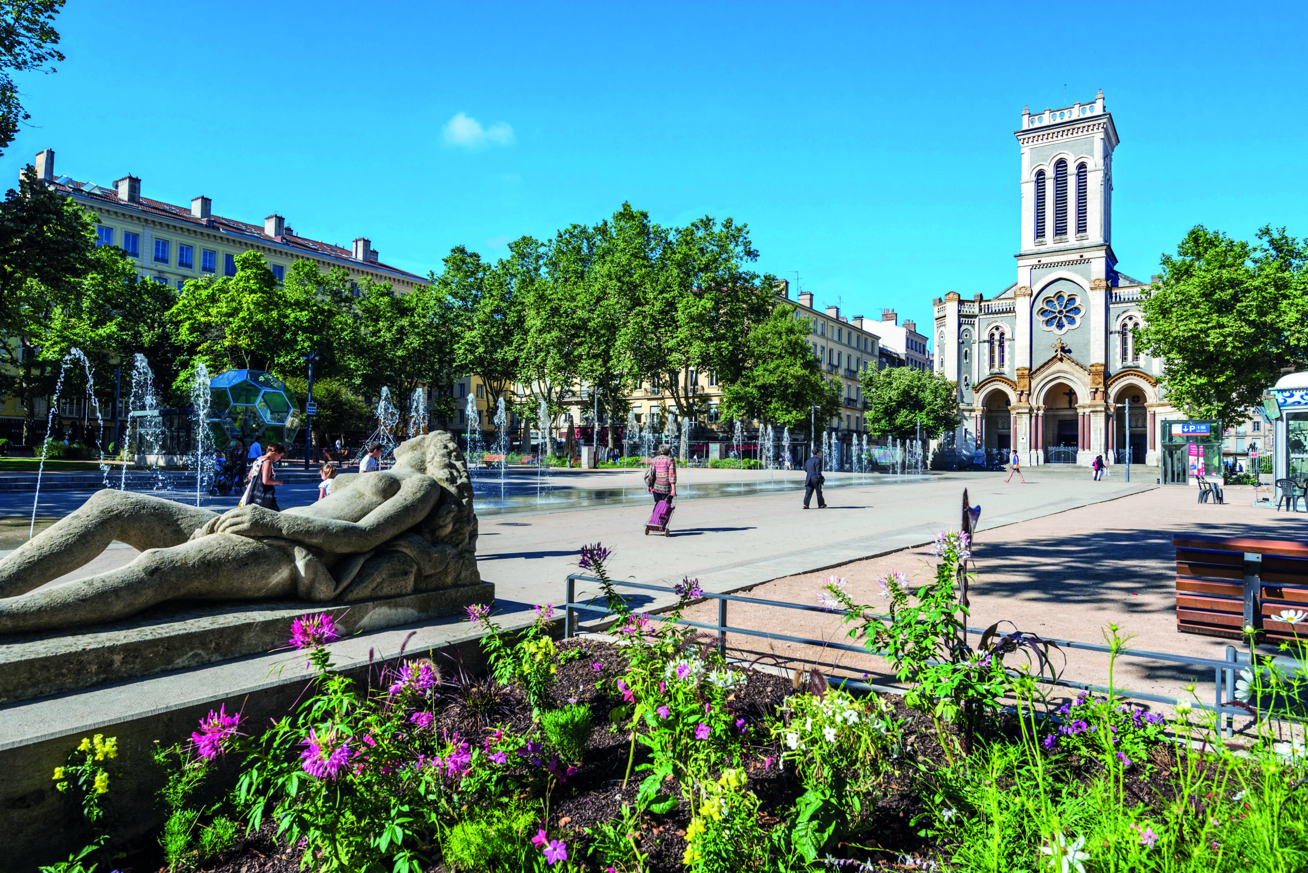 The square of Jean Jaures in Saint Etienne downtown with fountains. Morini Andre catholic church is at right background.